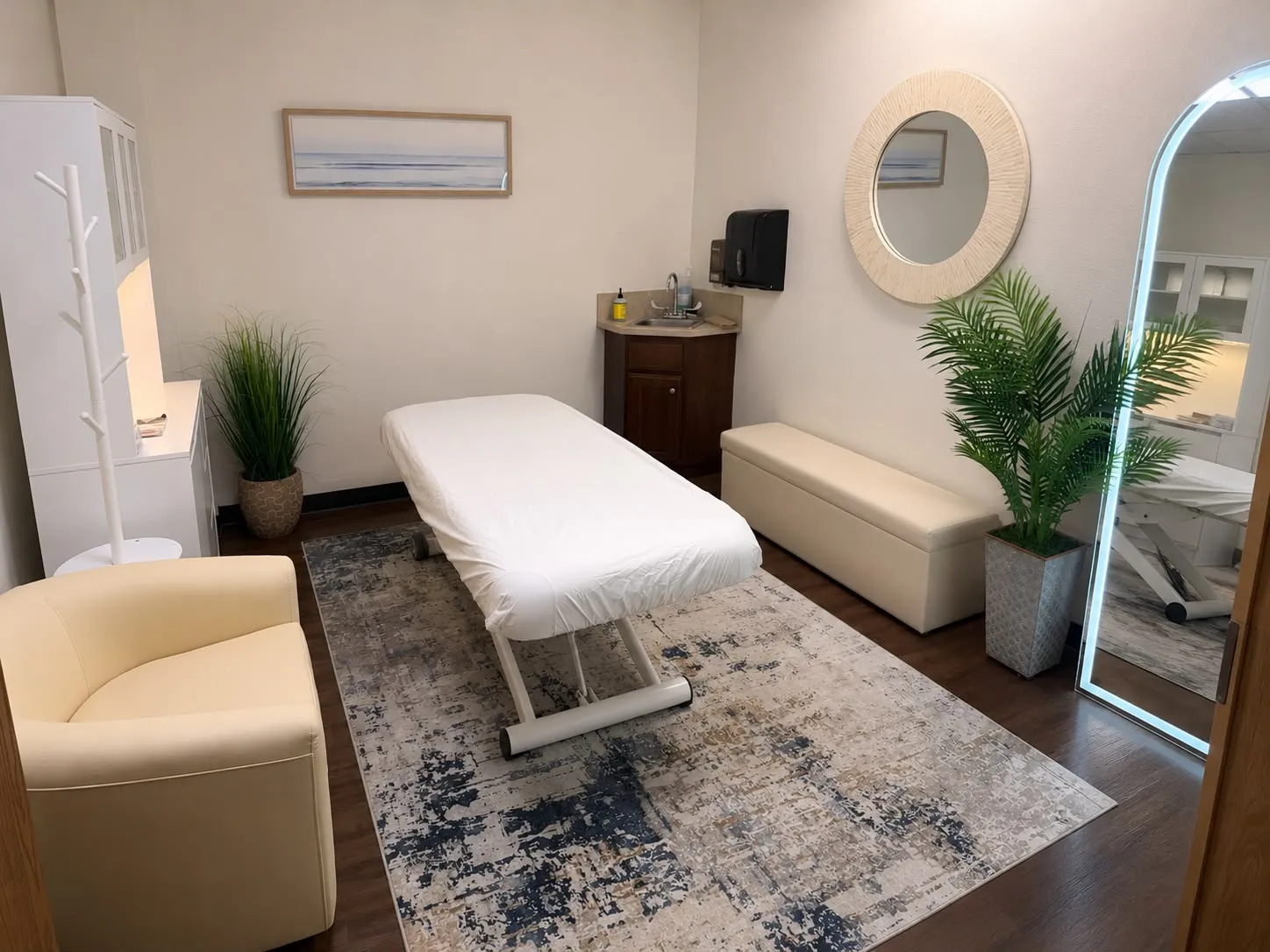 The treatment room at Lana Sculpt Studio: a single couch, a lit mirror, and a seating bench